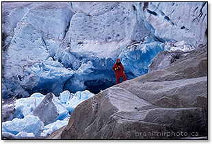 Man in a red survival suit in front of a glacier