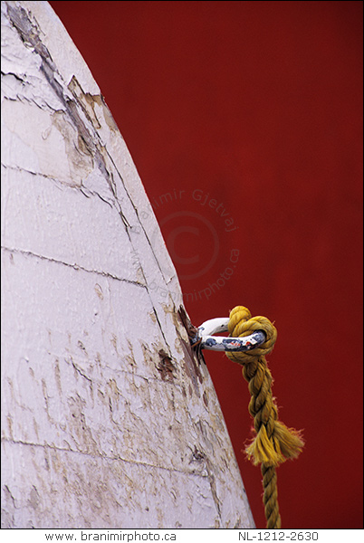 detail of a fishing boat with red building in background