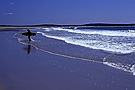 Woman on Martinique beach with surfboard, Hailfax