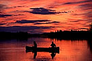 silhouette of a couple canoeing at sunset