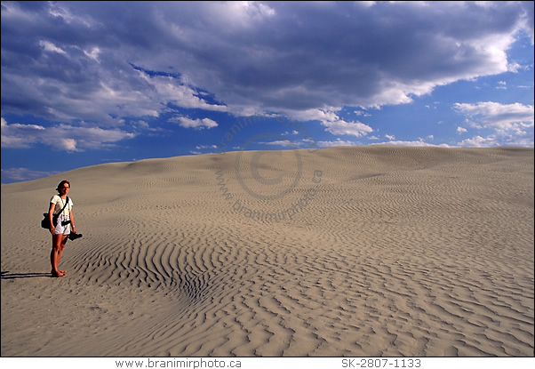 young woman standing on sand dune, Great Sand Hills